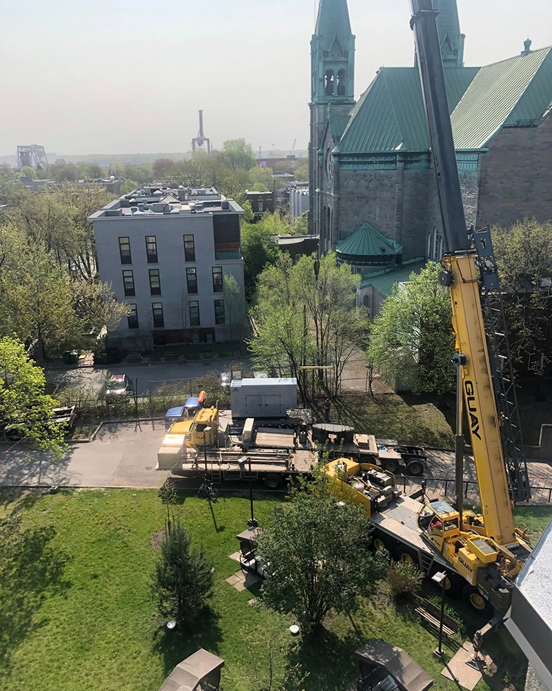Installation avec une grue d'une génératrice commerciale sur une toiture.